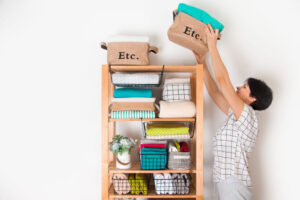 Ilustração com uma mulher organizando itens de casa