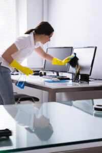  Ilustração de uma mulher limpando a tela de um computador com o pano microfibra