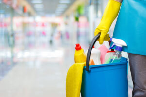  Ilustração de uma pessoa segurando um balde com diversos produtos de limpeza, inclusive o pano microfibra